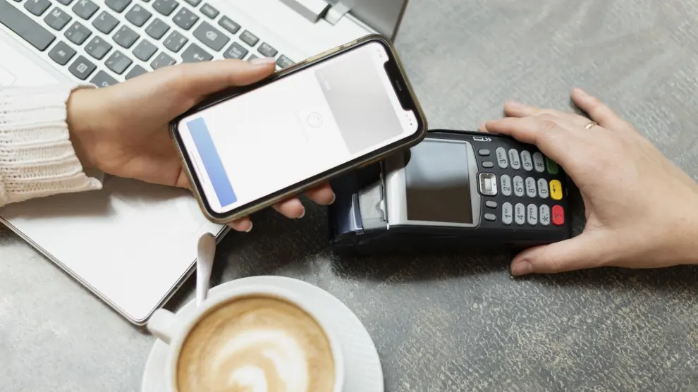 persona usando un telefono movil en banco